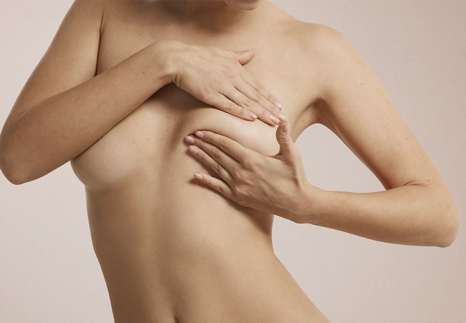 Mulher segurando a própria prótese de silicone
